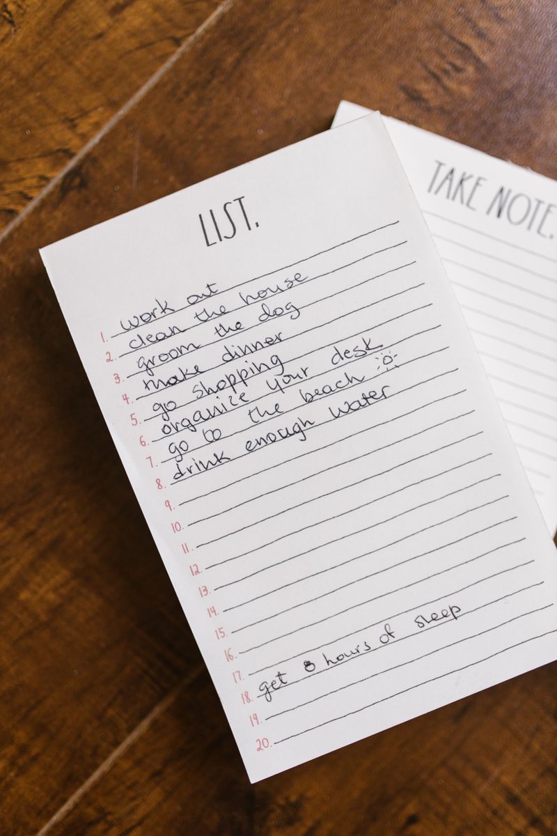 家族が食卓を囲みながら買い物リストを確認している明るいリビングの様子